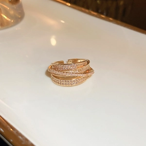 Close-up of multi-layer gold ring with shimmering cubic zirconia and adjustable open band