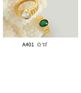 Detail of vintage gold rings with vertical texture featuring emerald and zircon stones