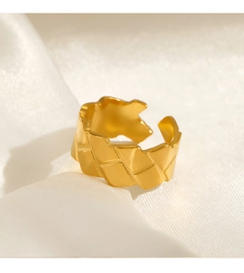 Detailed view of wide 18k gold plated stainless steel ring with quilted texture on silk