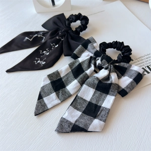 Close-up of bow hair scrunchies with skull prints and classic black white checkered patterns