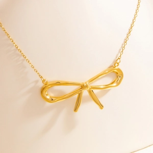 Macro shot of 18k gold butterfly pendant on titanium steel necklace for women