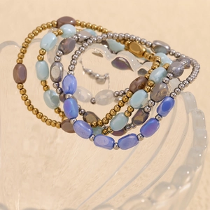 Detail of 4-piece stackable beaded bracelets set in gold and silver with blue glass beads