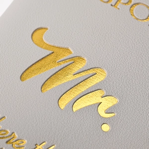 Close-up of gray PU leather passport holder with elegant gold foil Mr. lettering