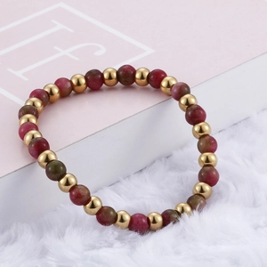 Titanium steel beaded bracelet with red garnet-style beads and gold accents on white fur