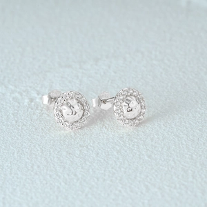 Detailed view of 925 sterling silver C-shaped stud earrings with diamond accents and texture
