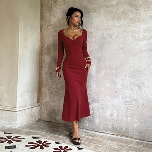 Deep red long sleeve bodycon dress with sweetheart neckline in a vintage studio setting