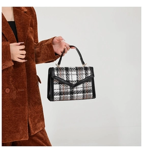 Detail der Vintage Karohandtasche mit schwarzem Lederbesatz und Cord-Blazer kombiniert
