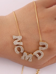 Detail eines goldenen ZCMD Buchstabenanhängers mit Zirkonia an einer feinen Box-Kette