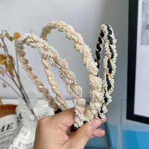 Detail of twisted pearl headbands with elegant beige and champagne woven ribbons