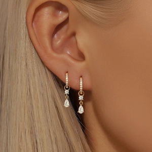 Close-up of gold chain tassel earrings with round and teardrop cubic zirconia stones