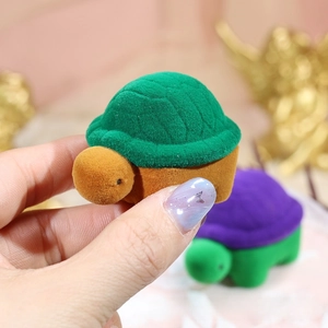 Detail of plush velvet turtle jewelry boxes in green and purple for rings and earrings