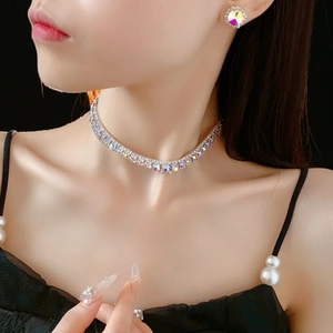 Close-up of sparkling square rhinestone necklace and round stud earrings set on a model
