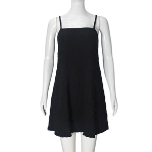 Detail of black mini dress with elegant pleated texture and spaghetti straps