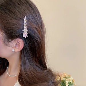Détail d'une élégante pince à cheveux fleurie en cristal rose sur le côté des cheveux
