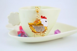 Macro shot of cute chicken keychain with sparkling crystals and golden details