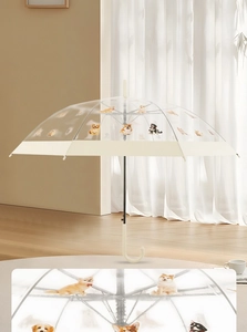 Close-up of transparent umbrella featuring detailed pet dog prints and ivory J-handle