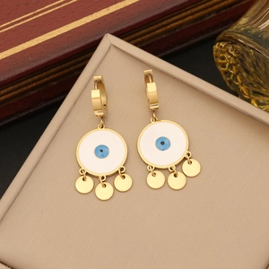 Golden evil eye earrings set on display box with blue enamel and dangling charms