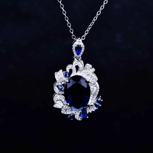 Macro shot of royal blue sapphire pendant featuring an oval stone in silver setting