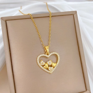Detailed view of a gold hollow heart pendant with sparkling cubic zirconia on beige silk