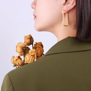 Polished gold rectangular earrings for women worn by model with minimalist style