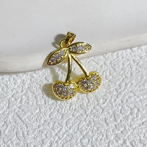Close-up of golden cherry pendant with zircon pavé and pearl for jewelry making