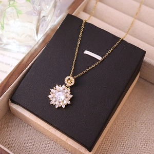 Luxurious gold necklace with sparkling zircon flower pendant on black velvet display