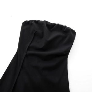 Close-up of a black strapless dress featuring elegant pleats and textured crepe fabric