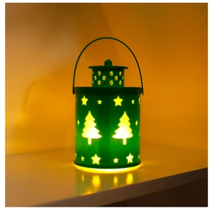 Detail of green metal Christmas lantern with warm light and festive cutout patterns