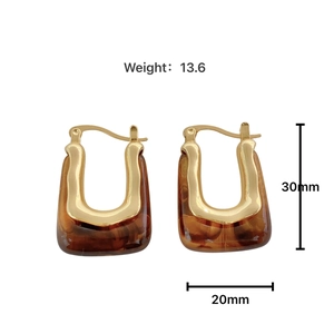 Detail view of U-shaped gold-plated resin earrings with tortoiseshell texture and measurements