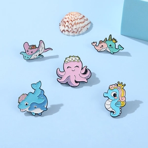 Set of 5 ocean animal enamel pins including octopus and whale on a blue background