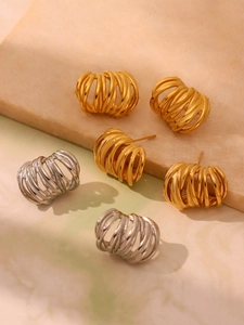 Macro shot of gold and silver C-shaped earrings with layered intertwined metal lines