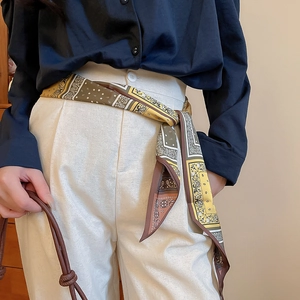 Detailed view of ginger and brown paisley print fabric scarf tied at the waistline