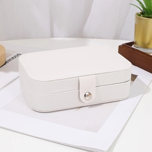 Close-up of white textured leather jewelry organizer box with silver snap button closure
