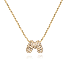 Macro shot of gold-plated letter M bubble pendant with sparkling cubic zirconia inlay