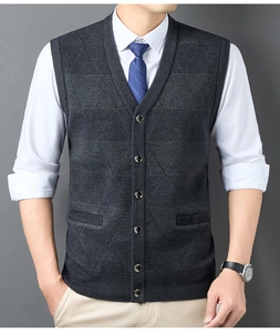 Detailed knit texture of dark grey button-up men's vest over white shirt and blue tie