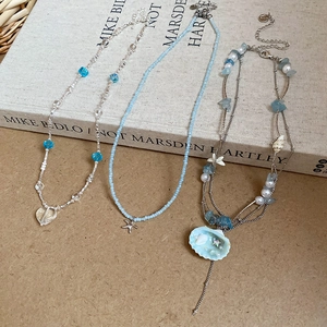 Detailed close-up of beach theme necklaces with starfish and sea shell glass bead charms