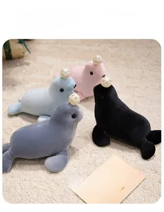 Multiple colors of soft seal plush toys with decorative ball on cream rug