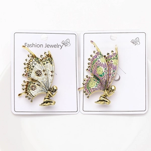 Detailed close-up of colorful enamel butterfly fairy brooches on a white jewelry card