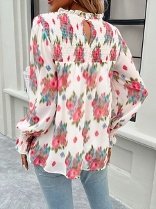 Detail of smocked back design on floral long sleeve blouse with ruffled stand collar