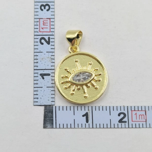 Detail view of gold Evil Eye pendant showing actual size next to a measuring tape