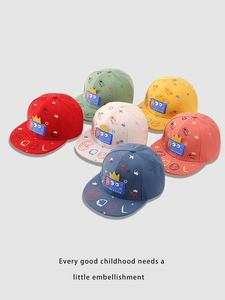Flat lay of colorful children's baseball caps with cartoon dinosaur patches and cool prints