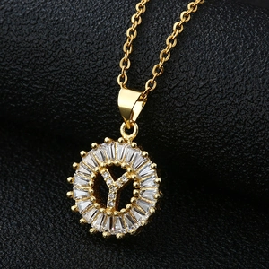 Vue macro du pendentif lettre Y serti de zircons sur fond de cuir noir texturé