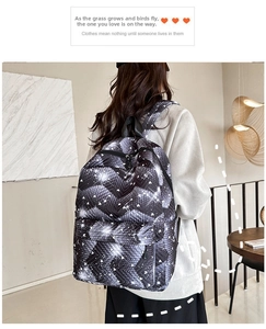 Detalle de mochila minimalista con estampado de corazones en blanco y negro llevada por modelo