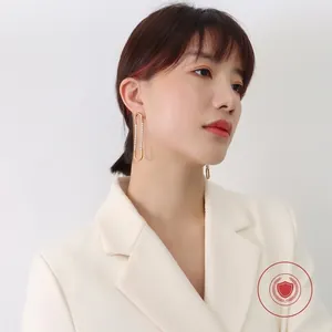 French style gold-plated U-shaped earrings with zircon accents worn by a model