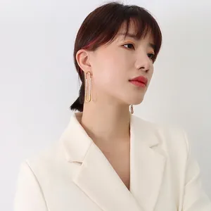 French style gold-plated U-shaped earrings with zircon accents worn by a model