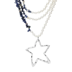 Detail of layered necklace featuring white pearls, blue stones, and a hammered star pendant