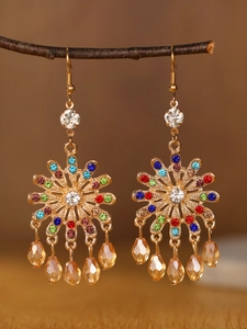 Detailed macro of bohemian chandelier earrings with colorful rhinestones and amber beads