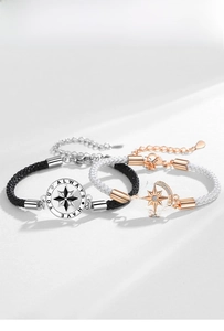 Détail de bracelets de couple tressés avec charmes boussole et chiffres romains gravés