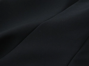Macro detail of high-elastic black knit fabric texture showing fine weave and soft drape
