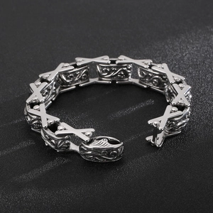 Macro detail of retro floral engraving and X-shaped links on stainless steel bracelet